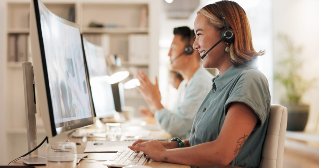 Frau telefoniert mit moderner Telefonanlage und lächelt